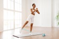 Happy Black Woman In White Sportswear Exercising With Bands