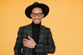 Happy black young man wears elegant dark suit posing with pleased smile. Indoor photo of relaxed mulatto male model in Royalty Free Stock Photo