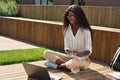 Happy African girl student studying online using laptop sitting outside. Royalty Free Stock Photo