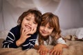 Happy, blanket fort and portrait of kids relaxing, bonding and playing together at home. Smile, cute and young girl and Royalty Free Stock Photo