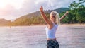 Happy blond beautiful women raising her hands on Ao Nang beach at sunset, Krabi Thailand