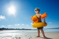 Happy blond boy on the beach with inflatable yellow duck buoy Royalty Free Stock Photo
