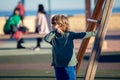 Happy blond boy playing in the park resting on wooden swing Royalty Free Stock Photo