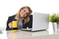 Happy blond business woman working on computer at office desk smiling Royalty Free Stock Photo