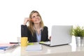 Happy blond business woman working on computer at office desk thinking Royalty Free Stock Photo