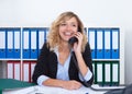 Happy blond businesswoman at office at phone Royalty Free Stock Photo