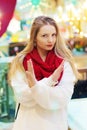 happy blond girl in red scarf show warning sign with point finger