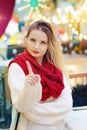 happy blond girl in red scarf show warning sign with point finger