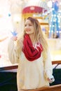 happy blond girl in red scarf show warning sign with point finger
