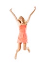 Happy blond girl wearing pink dress jumping in the air against white background Royalty Free Stock Photo