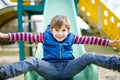 Happy blond kid boy having fun and sliding on outdoor playground Royalty Free Stock Photo