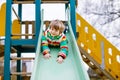 Happy blond kid boy having fun and sliding on outdoor playground Royalty Free Stock Photo