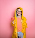 Happy blond kid in yellow coat eat lollipop, concept of dental health. sweet tooth. yummy. hipster school child with Royalty Free Stock Photo