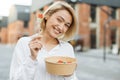 Happy blond smiling woman freelancer, manager, business lady, eating fresh vegetable salad Royalty Free Stock Photo