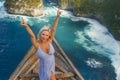 Happy blond tourist woman feeling free on the stunning view of beautiful sea cliff beach at viewpoint enjoying exotic Summer Royalty Free Stock Photo