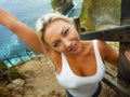 Happy blond tourist woman feeling free on the stunning view of beautiful sea cliff beach at viewpoint enjoying exotic Summer Royalty Free Stock Photo