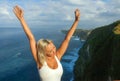 Happy blond tourist woman feeling free on the stunning view of beautiful sea cliff beach at viewpoint enjoying exotic Summer Royalty Free Stock Photo