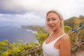 Happy blond tourist woman feeling free on the stunning view of beautiful sea cliff beach at viewpoint enjoying exotic Summer Royalty Free Stock Photo