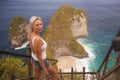 Happy blond tourist woman feeling free on the stunning view of beautiful sea cliff beach at viewpoint enjoying exotic Summer Royalty Free Stock Photo