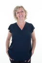 Happy blonde caucasian senior woman smiling and looking beautiful isolated on white background with hands in pockets of jeans Royalty Free Stock Photo