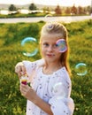 Happy blonde girl blowing soap bubbles Royalty Free Stock Photo