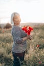 Happy blonde hair woman lady holding red poppies bouquet in the field at sunset Royalty Free Stock Photo