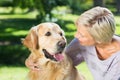 Happy blonde with her dog in the park Royalty Free Stock Photo