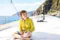 Happy blonde kid boy enjoying sailing boat trip. Family vacations on ocean or sea on sunny day. Healthy beautiful school Royalty Free Stock Photo