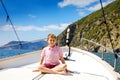 Happy blonde kid boy enjoying sailing boat trip. Family vacations on ocean or sea on sunny day. Healthy beautiful school Royalty Free Stock Photo