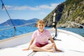 Happy blonde kid boy enjoying sailing boat trip. Family vacations on ocean or sea on sunny day. Healthy beautiful school Royalty Free Stock Photo