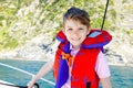 Happy blonde kid boy enjoying sailing boat trip. Family vacations on ocean or sea on sunny day. Healthy beautiful school Royalty Free Stock Photo