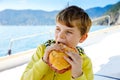 Happy blonde kid boy enjoying sailing boat trip. Family vacations on ocean or sea on sunny day. Healthy beautiful school Royalty Free Stock Photo