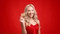 Happy Blonde Lady Holding Credit Card Winking Eye, Red Background Royalty Free Stock Photo