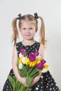 Happy blonde little girl with tulips