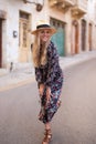 Happy blonde Mediterranean woman floral pattern dress posing