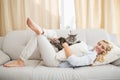 Happy blonde with pet cat on sofa Royalty Free Stock Photo