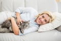 Happy blonde with pet cat on sofa Royalty Free Stock Photo