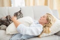 Happy blonde with pet cat on sofa Royalty Free Stock Photo