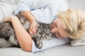 Happy blonde with pet cat on sofa Royalty Free Stock Photo