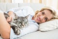 Happy blonde with pet cat on sofa Royalty Free Stock Photo