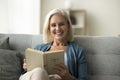 Happy blonde senior retired woman reading paper book Royalty Free Stock Photo