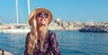Happy blonde tourist lady enjoying mediterranean city at sea