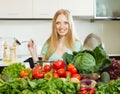 Happy blonde woman cooking with vegetables in kitchen Royalty Free Stock Photo