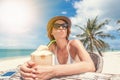 Happy blonde woman in hat and sunglasses on the tropical beach s Royalty Free Stock Photo