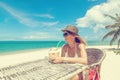 Happy blonde woman in hat and sunglasses on the tropical beach s Royalty Free Stock Photo