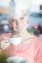 Happy blonde woman holding a cup of coffee Royalty Free Stock Photo