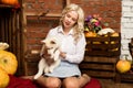 Happy blonde woman with husky puppy on a autumn harvest background