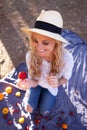 Happy blonde woman at picnic showing strawberry