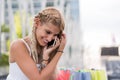 Happy blonde woman shopping and using mobile phone smiling outdo Royalty Free Stock Photo