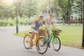 Happy boho chic girls gather wild flowers on bicycle ride Royalty Free Stock Photo